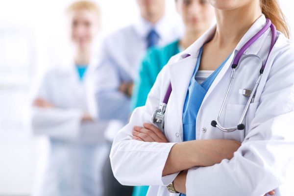 Attractive female doctor in front of medical group Attractive female doctor in front of medical group