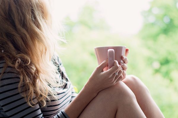 Peaceful woman relaxing at home with cup of tea or coffee Peaceful woman relaxing at home with cup of tea or coffee